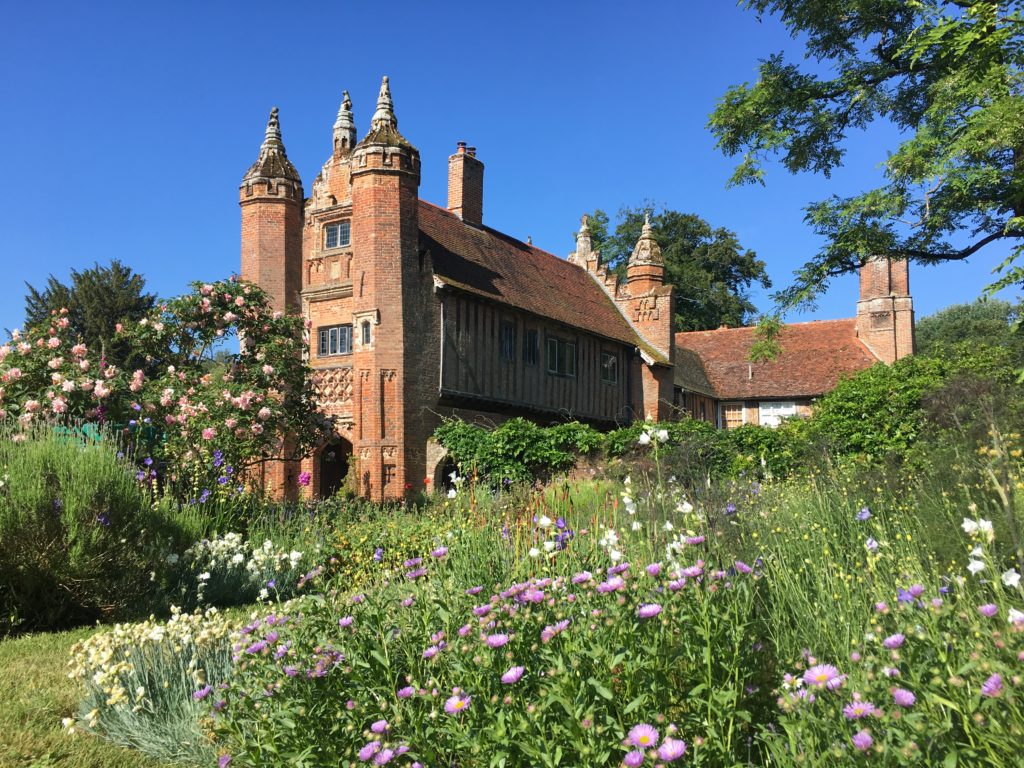 A picture of a Tudor gatehouse set in and English garden.