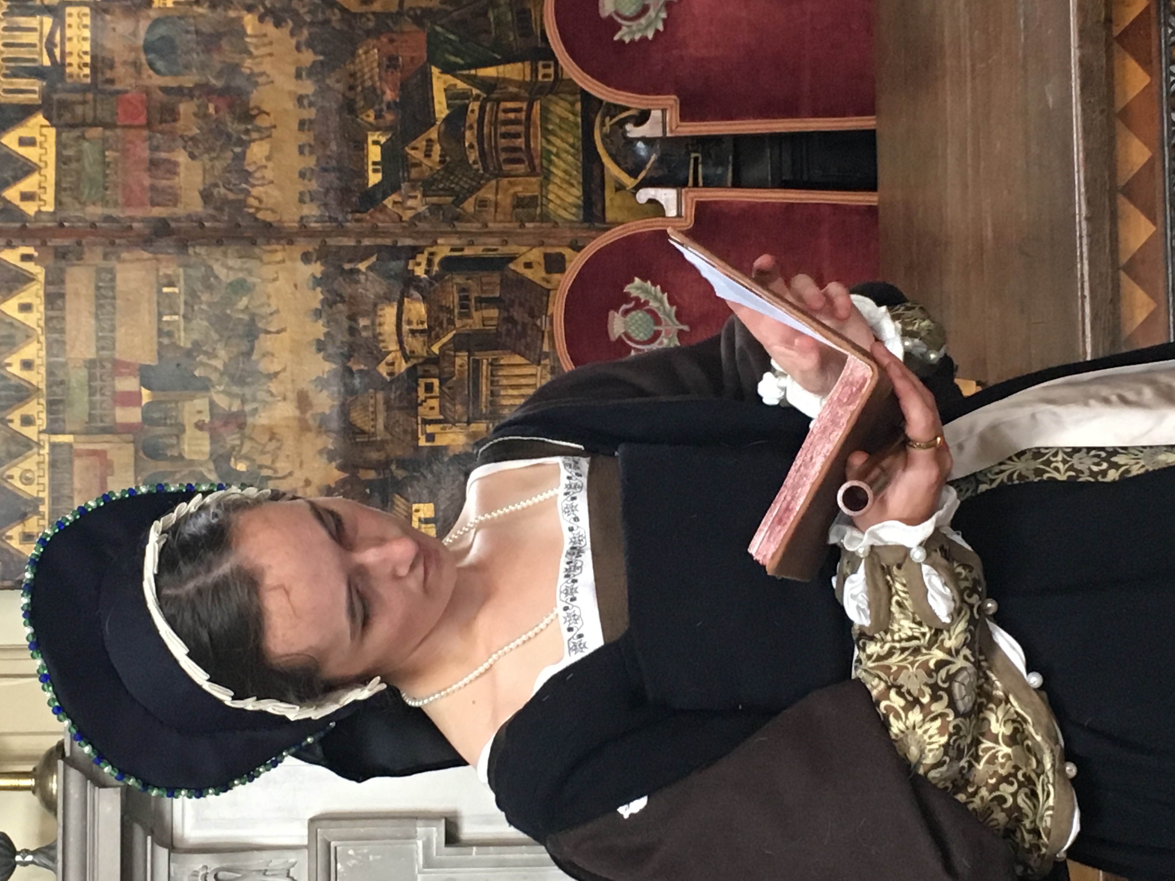 Tudor lady reading a book at Kentwell