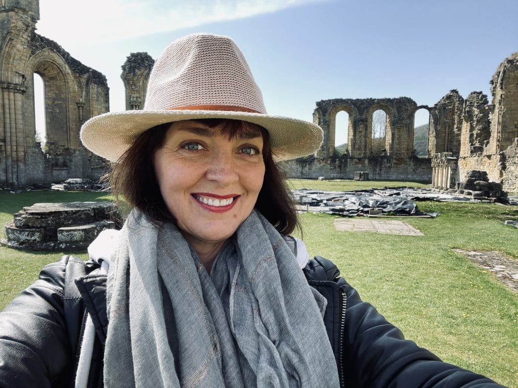 The Tudor Travel Guide exploring Tudor England with a picture of abbey ruins in the background