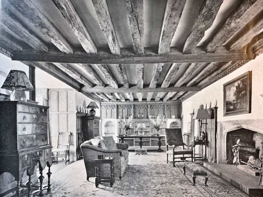 The interior of the lower hall at Swanborough Manor, showing the Tudor fireplace, beamed, oak ceiling and remnant of a carved oak screen at the lower end of the hall.