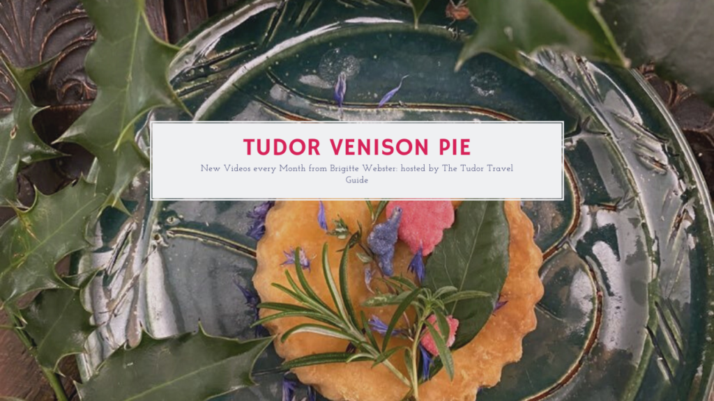 A venison pie on a green plate and decorated by herbs and edible flowers.