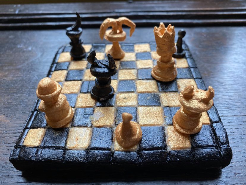 A chessboard made out of marchpane in black and gold
