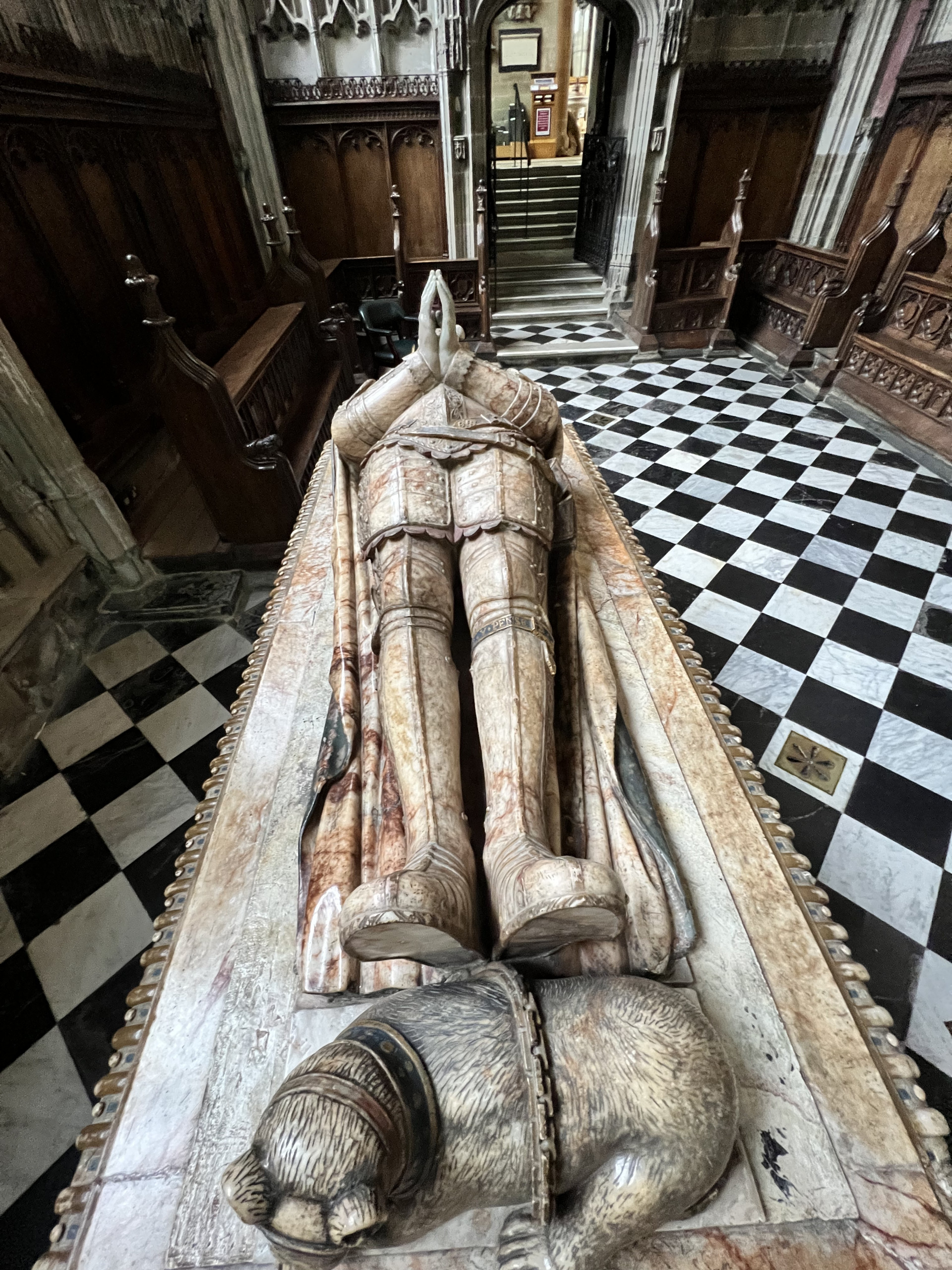 View of tomb effigy from above with a bear at the effigy's feet.